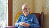 Male Home Care Package client sitting in an armchair and smiling